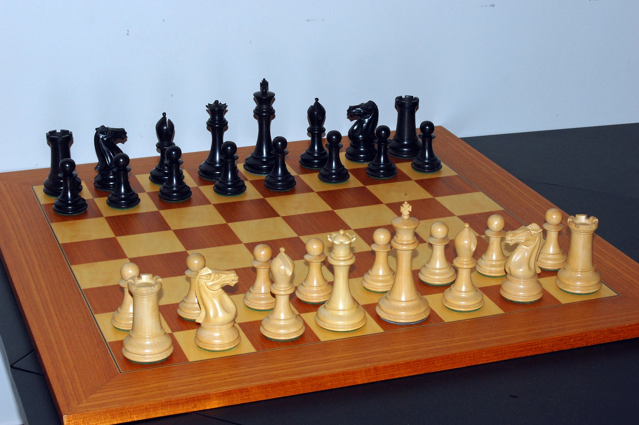 White chess pieces in starting location: pawns in second line, and others from left to right: tower, horse, bishop, queen, king, bishop, horse, tower in first line